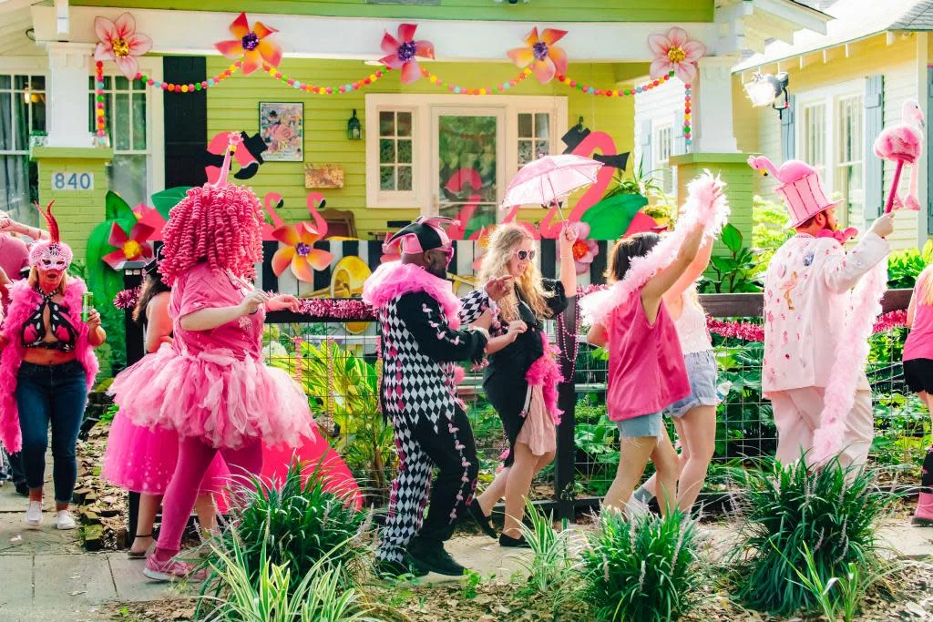 Costumed revelers in pink dancing at the Spanish Town parade in Baton Rouge